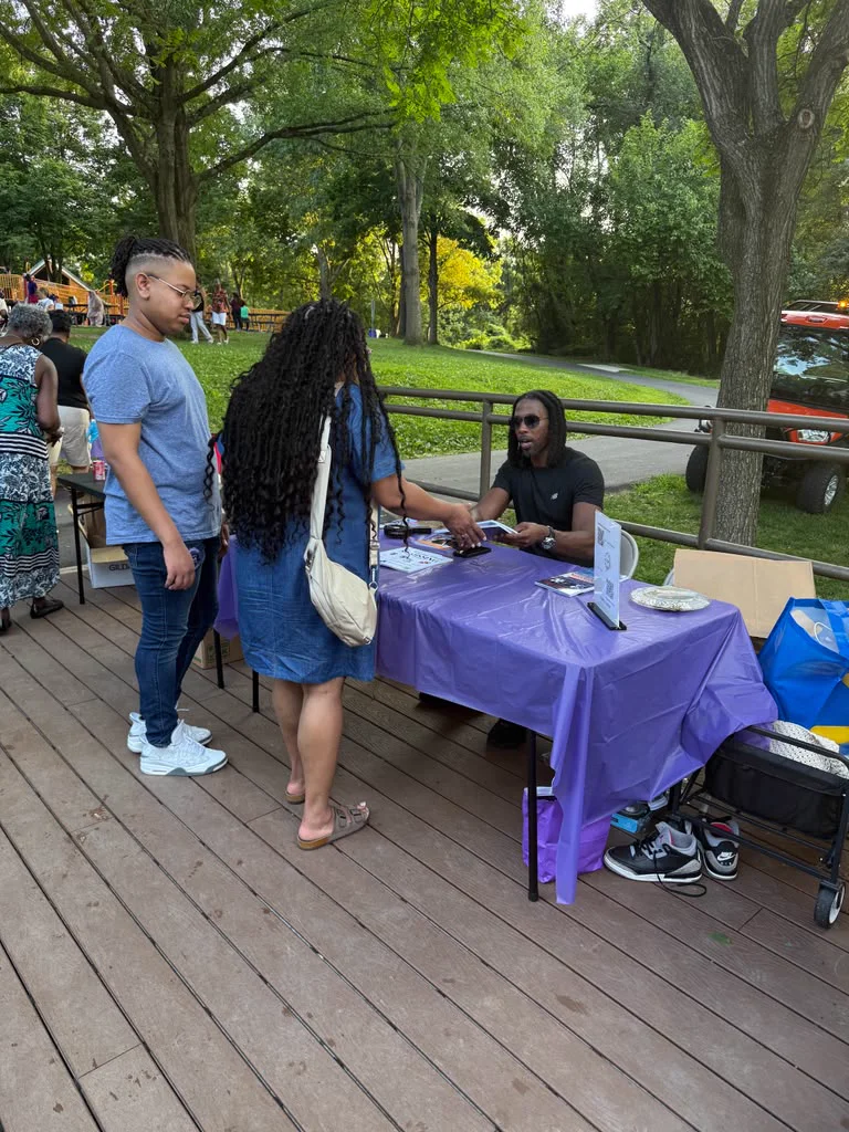 Marco Lomax signing books for readers at an outdoor community event