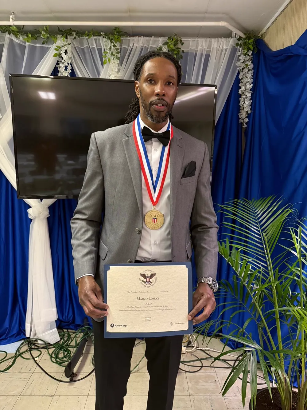 Marco Lomax holding his Presidential Gold Award certificate and medal